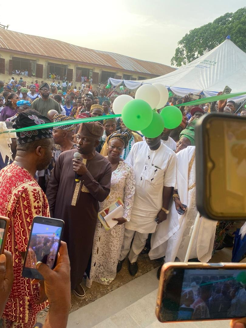 Official opening of the new school buildings at Onipe, 9 November 2024 &mdash; large crowd, Oyo State government representative at the microphone, green and white balloons