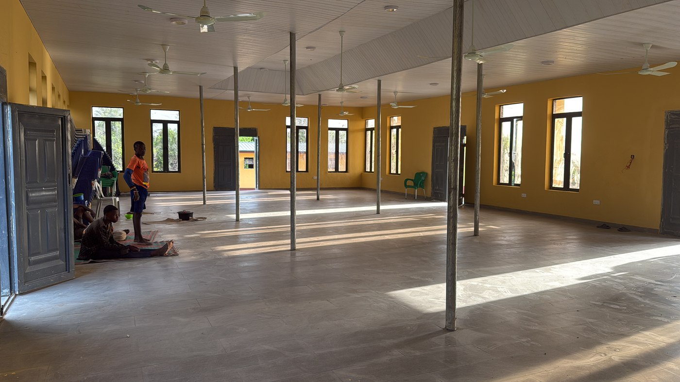 Interior of the Engr. Seyi Makinde Hall &mdash; large open space, ceiling fans, tiled floor